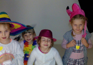 Dziewczynki w kolorowych nakryciach głowy pozują do zdjęcia.